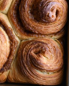 four cinnamon rolls sitting in a baking pan