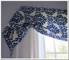 blue and white curtains hanging on the side of a window