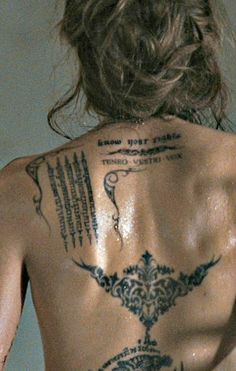 the back of a man with tattoos on his body