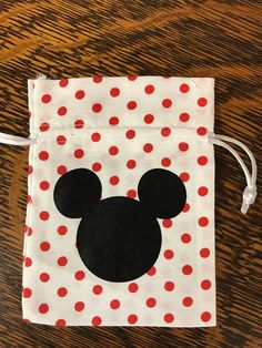 a mickey mouse bag with red and white polka dots on the front, sitting on a wooden table