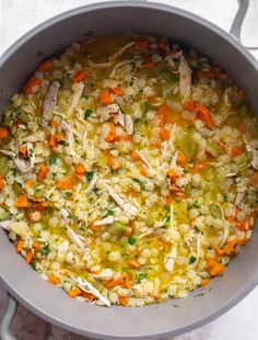 a pot filled with rice and vegetables on top of a table