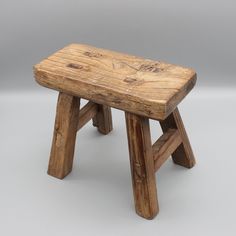 a small wooden bench sitting on top of a white floor