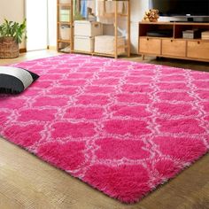 a bright pink rug is in the middle of a living room