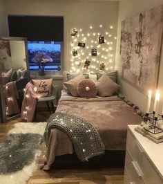 a bedroom decorated in pink and white with lights