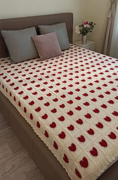 a crocheted blanket on top of a bed with pillows