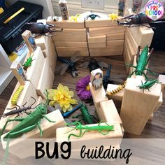 a group of wooden boxes with bugs and flowers in them on the floor next to a piano