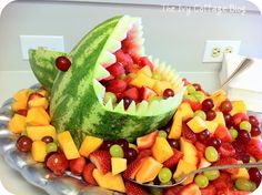 a watermelon shark made out of fruit on a platter