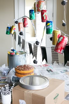 a box with a donut on it sitting next to some soda cans and other items