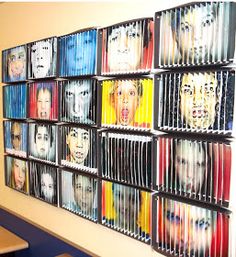 a group of people's faces are painted on the side of a wall in a classroom