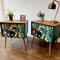 two side tables painted with tropical birds and plants, one has a lamp on top