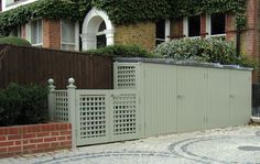 a large gate in front of a brick building with ivy growing on the side of it