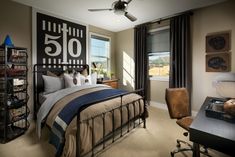 a bed room with a neatly made bed next to a window and a ceiling fan