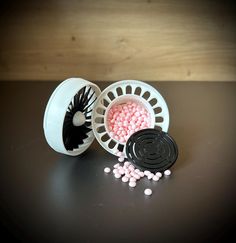 two plastic containers filled with pink and white candy