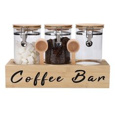 three glass jars filled with coffee beans and marshmallows on a wooden stand