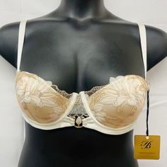 -Cut Down Push Up Cup -Lilium Embroidery Of Swiss-Design -Thermo-Cut Flowers On Crystal Tulle -Removeable Shoulder Straps -Gold-Plated Hardware & Pearl Barbell Ring -Hook & Eye Fastening -Comes With Honey Birdette Hanger Cream Lace Underwire Bra, Cream Bra With Delicate Lace, Wedding Lace Bra In Beige, Cream Delicate Lace Bra, Fitted Cream Bra With Removable Pads, Elegant White Bra With Lined Body, Elegant Beige Bra With Lined Body, Elegant Full Cup Cream Bra, Delicate Fitted Wedding Bra