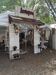 an antique store is set up in the middle of a field with tables and chairs