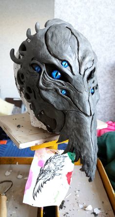 a mask with blue eyes sitting on top of a table