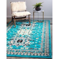 a blue area rug with a chair and plant in the corner next to it on top of a hard wood floor