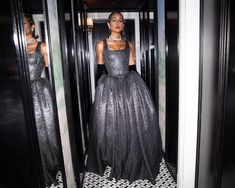 two mannequins dressed in black and silver gowns are seen through mirrors