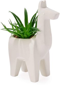 a planter shaped like a giraffe with green plants in it's mouth