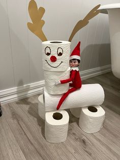 an elf is sitting on top of two toilet paper rolls