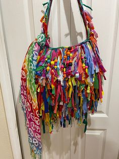 a multicolored purse hanging on a door