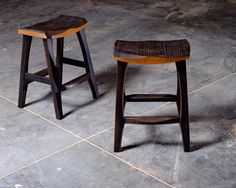 two wooden stools sitting on top of a tile floor next to eachother