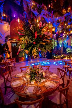 a table set up with place settings and flowers on it for an elegant dinner party