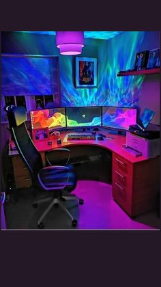 a computer desk with multiple monitors on it in a room lit up by colorful lights