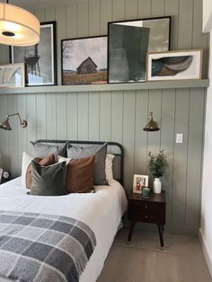 a bed sitting in a bedroom next to two framed pictures on the wall above it