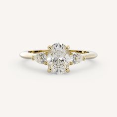 an oval cut diamond ring with three pear shaped diamonds on the band and side stones