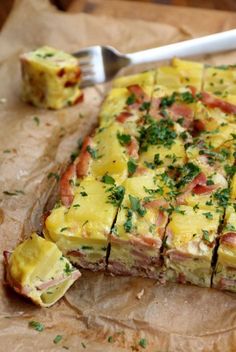 a piece of food that is on top of a brown paper with a fork next to it