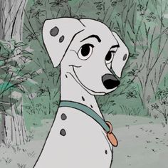 a dalmatian dog sitting in the grass next to a tree