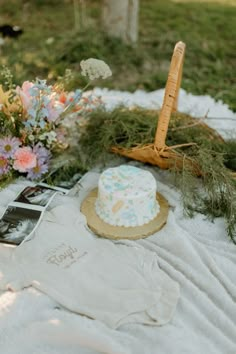 a cake sitting on top of a white table cloth next to flowers and an umbrella