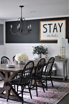 a dining room table with chairs and a chandelier hanging from it's ceiling