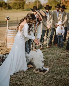 a bride and groom are preparing to cut their wedding cake at the end of an outdoor ceremony