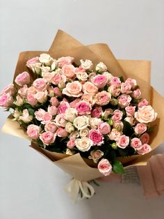 a person holding a bouquet of pink and white flowers