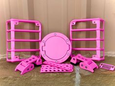 pink plastic parts are sitting on the ground