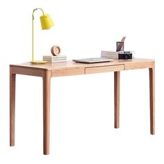 a wooden desk with a lamp on top of it and books sitting on the table