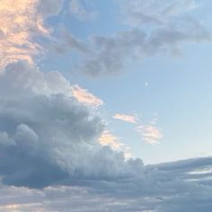 the sky is filled with clouds and some birds