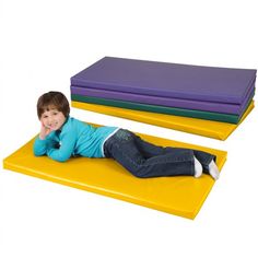 a young boy laying on top of three foam mattresses