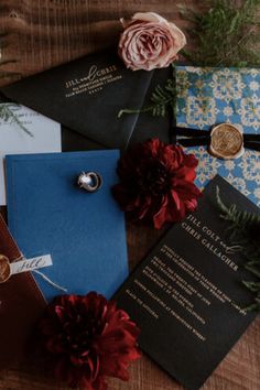 the wedding stationery is laid out on top of each other, with red flowers