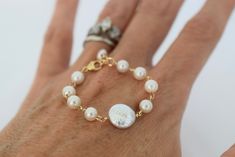 A tiny freshwater pearl & 14k gold filled bracelet for your precious little one. Handcrafted with baby white freshwater pearls, a white round coin pearl centerpiece and 14k gold filled incidentals. Materials: 5mm freshwater pearls, 10mm round coin pearl, 14k gold filled wire & lobster clasp. Length: 4" long with a 1" extender (fits 3-6 mos. - up to 18 mos.) Each piece is meticulously handcrafted to order by me in my Florida studio. Please allow 3-5 business days for production. Pearl Charm Jewelry For First Communion, Everyday Pearl Bracelet With Pearl Charm, Everyday Pearl Charm Bracelet, Elegant Pearl Bracelet With Pearl Charm For First Communion, Personalized Pearl Bracelet, White Pearl Drop Bracelet In 14k Gold Filled, Baby Jewellery, Pearl Centerpiece, Baby Pearls