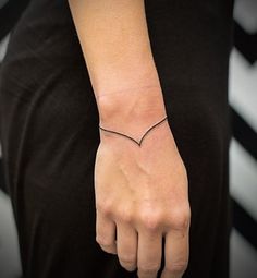 a woman's arm with a small heart tattoo on it