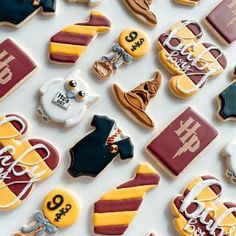 many decorated cookies are displayed on a white surface with the words harry potter spelled in gold and red