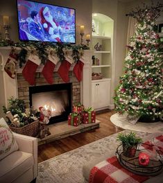 a living room decorated for christmas with a fireplace and large tv above the fire place