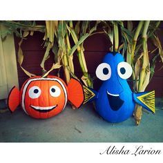 two pumpkins decorated to look like fish next to corn stalks with eyes on them