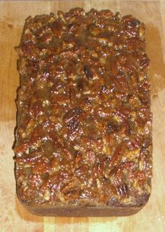 a loaf of pecan bread sitting on top of a wooden cutting board