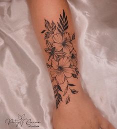 a black and white flower tattoo on the foot