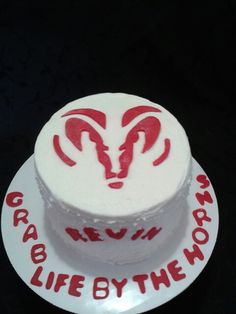 a white cake with red icing and the words life by the horns on it